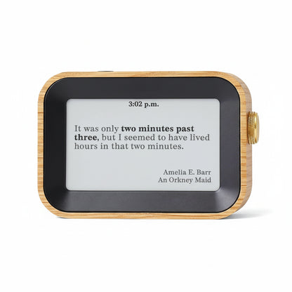 Digital clock with wooden frame displaying a quote by Amelia E. Barr.